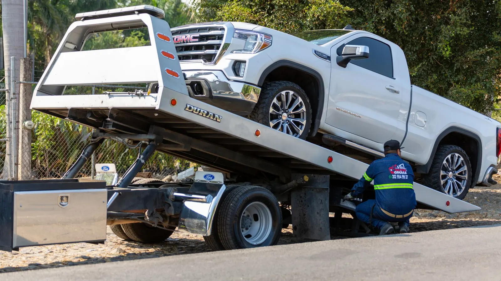 A car loaded on the back of a tow truck