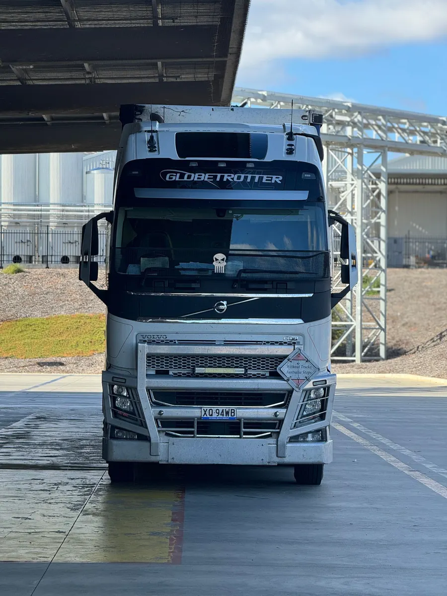 A semi truck parked outdoors beside a building
